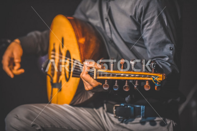  شاب عربي سعودي أنيق يعزف على الجيتار, الغيتار (الجيتار أو القِيثَارَة ) آلة موسيقية وترية بأوتار مدقوقة , عزف الموسيقى الهادئة الراقية