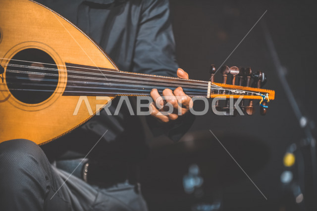  شاب عربي سعودي أنيق يعزف على الجيتار, الغيتار (الجيتار أو القِيثَارَة ) آلة موسيقية وترية بأوتار مدقوقة , عزف الموسيقى الهادئة الراقية