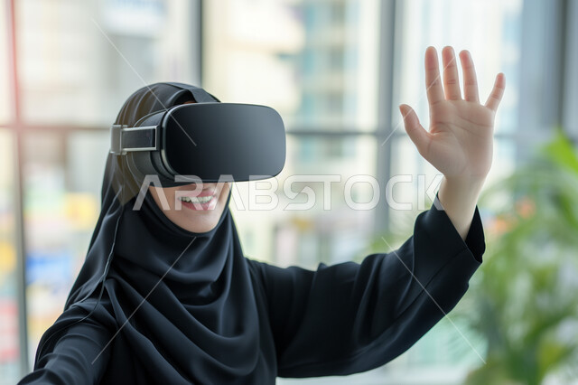الإندماج والتفاعل ومحاكاة العالم الخيالي, صورة مقربة لإمرأه عربيه سعوديه خليجيه محجبة ترتدي نظارة الواقع الإفتراضي ترفع يدها للاعلى بإيماءات التلويح، مفهوم التسليه والترفيه, قضاء وقت ممتع, تطور التقنيه والتكنولوجيا