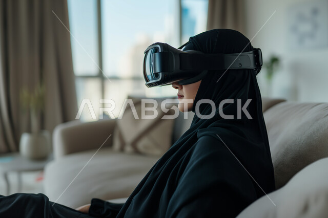 التفاعل والإندماج ومحاكاة العالم الخيالي, صورة مقربة لإمرأه عربيه سعوديه خليجيه محجبة ترتدي نظارة الواقع الإفتراضي تجلس على كرسي مريح، مفهوم التسليه والترفيه, قضاء وقت ممتع, تطور التقنيه والتكنولوجيا