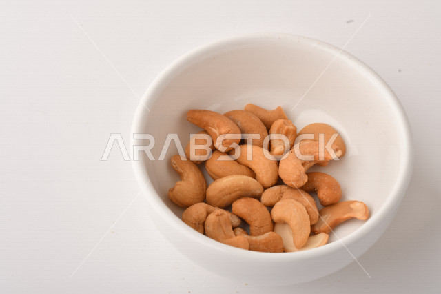 الكاجو(الكاشو) نوع من انواع المكسرات المشهورة , الكاجو المملح , مكسرات صحية ولذيذة , عنصر غذائي مفيد للصحة , وجبة خفيفة , خلفية بيضاء