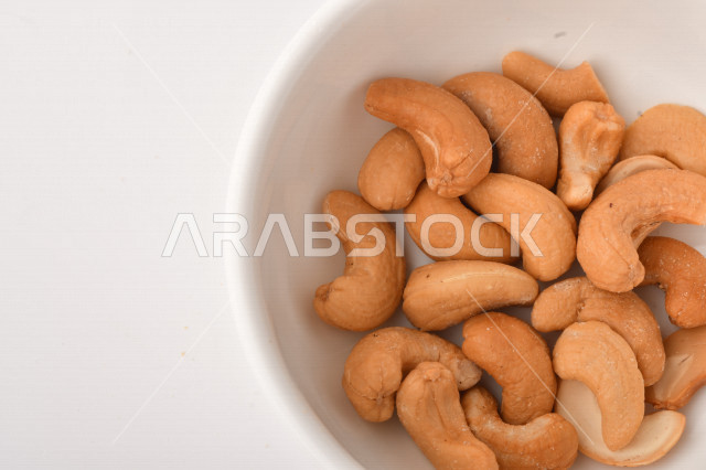 الكاجو(الكاشو) نوع من انواع المكسرات المشهورة , الكاجو المملح , مكسرات صحية ولذيذة , عنصر غذائي مفيد للصحة , وجبة خفيفة , خلفية بيضاء