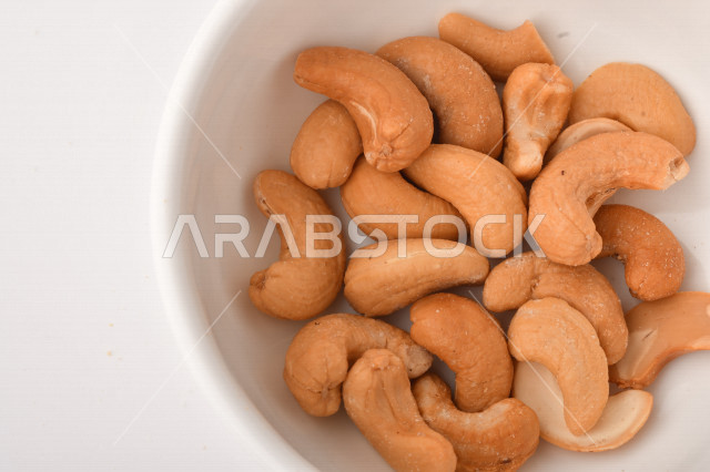 الكاجو(الكاشو) نوع من انواع المكسرات المشهورة , الكاجو المملح , مكسرات صحية ولذيذة , عنصر غذائي مفيد للصحة , وجبة خفيفة , خلفية بيضاء