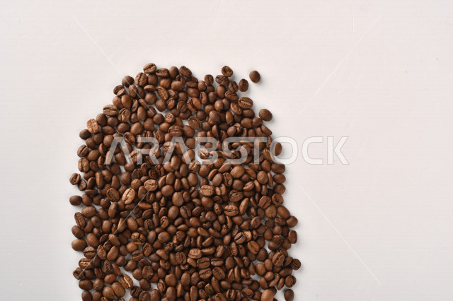 حبوب البن (بذرة نبات القهوة) نوع من أنواع المشروبات المنشطة ذهنياً , بذور البن المحمصة,  بذور البن الطازجة الطبيعية  , خلفية بيضاء
