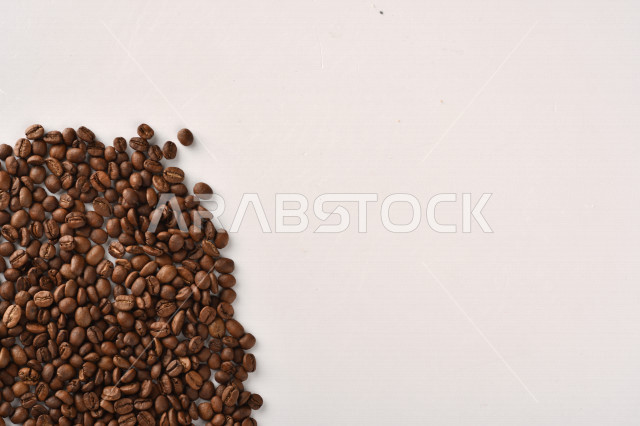 حبوب البن (بذرة نبات القهوة) نوع من أنواع المشروبات المنشطة ذهنياً , بذور البن المحمصة,  بذور البن الطازجة الطبيعية  , خلفية بيضاء