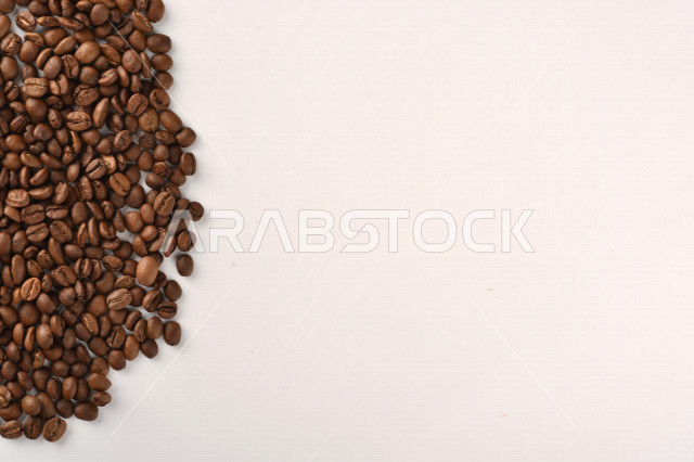 حبوب البن (بذرة نبات القهوة) نوع من أنواع المشروبات المنشطة ذهنياً , بذور البن المحمصة,  بذور البن الطازجة الطبيعية  , خلفية بيضاء