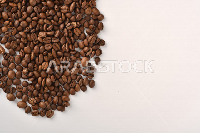 حبوب البن (بذرة نبات القهوة) نوع من أنواع المشروبات المنشطة ذهنياً , بذور البن المحمصة,  بذور البن الطازجة الطبيعية  , خلفية بيضاء