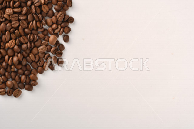 حبوب البن (بذرة نبات القهوة) نوع من أنواع المشروبات المنشطة ذهنياً , بذور البن المحمصة,  بذور البن الطازجة الطبيعية  , خلفية بيضاء