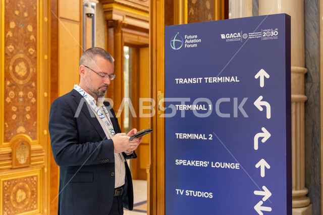 Popular cultural events and conferences, A foreign visitor stands next to a blue signboard at the Future of Aviation Conference in Riyadh, Saudi Arabia, Shaping the future of international air transport, Developing environmental sustainability in civil aviation, Saudi Vision 2030