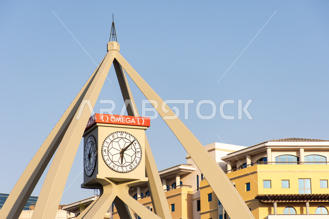 التصميم الهندسي المعماري على الطراز الحديث لبرج الساعة في ديرة في مدينة دبي وقت النهار، المنشآت و المباني السكنية و التجارية، التطور والنمو العمراني في الإمارات العربية المتحدة، مقصد السياح والزائرين من مختلف البلدان، معالم وأماكن سياحية مشهورة