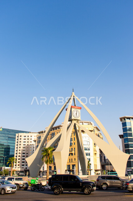 Famous tourist places and landmarks, traffic of cars on roads and asphalt streets, urban growth and progress in the United Arab Emirates, modern architectural art of the Deira Clock Tower in Dubai during the day, residential and commercial buildings and structures