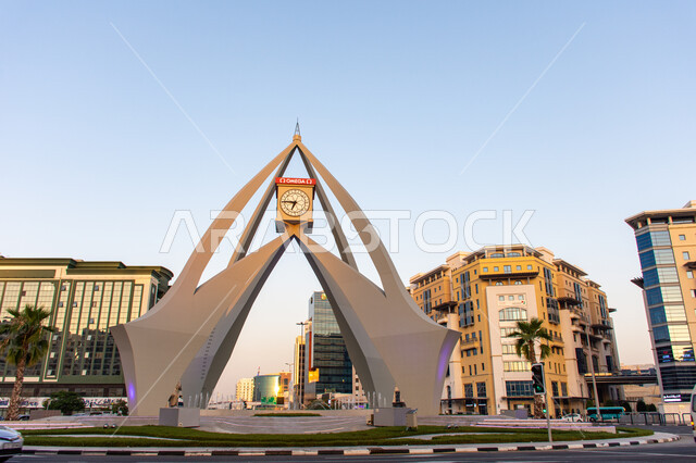 المنشآت والمباني السكنية والتجارية، الفن الهندسي المعماري على الطراز الحديث لبرج الساعة في ديرة في مدينة دبي وقت النهار، التقدم والنمو العمراني في الإمارات العربية المتحدة، معالم وأماكن سياحية مشهورة، حركة مرور السيارات في الشوارع والطرقات الاسفلتية
