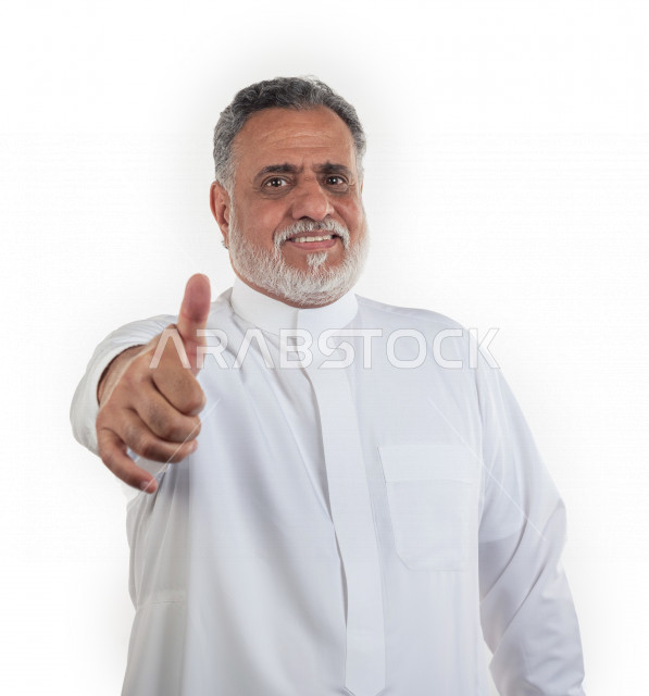 Portrait of an old Saudi Arab man pointing his thumb with the like sign, wearing a white dress with a shemagh and headband, white background, an elderly man with a smiley face doing the thumbs up sign, the concept of body language and facial expressions