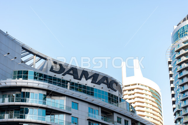 النمو والتطوير المعماري في الامارات العربية المتحدة، لوغو شركة داماك العقارية باللغة الانكليزية، الشركات المعمارية الرائدة، مفهوم بيع وشراء الشقق، صورة مقربة لمبنى فخم في دبي