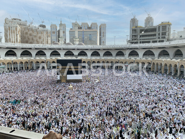 Performing Hajj and Umrah rituals in Mecca, a top view of pilgrims circling the Kaaba in the Grand Mosque, the concept of worship and getting closer to God, sacred Islamic religious places and landmarks in the Kingdom of Saudi Arabia