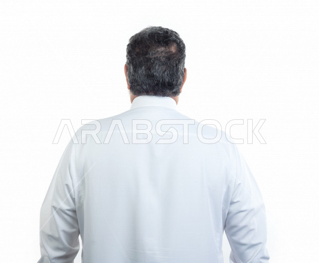 بورتريه رجل عربي سعودي كبير بالسن يقوم بجلسة تصوير من الخلف , يرتدي ثوب أبيض , خلفية بيضاء , الواجه الخلفية لرجل مسن يلتقط الصور , مفهوم تعابيرالوجه ولغة الجسد