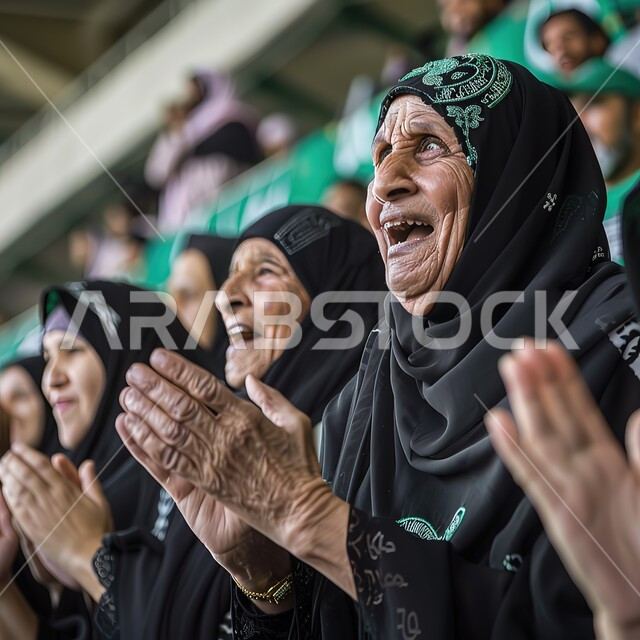 ايماءات وجه ويدين تدل على السعادة والفرح بفوز الفريق المفضل، صورة مقربة لنساء كبار بالسن عربيات خليجيات سعوديات محجبات يقفون في مدرج الملعب لحضور المباراة، الشغف بكرة القدم، التشجيع والحماس لتحقيق النجاح