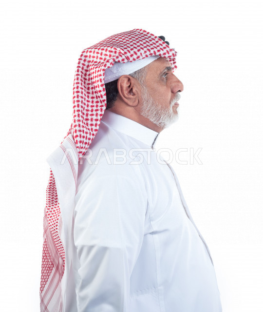 بورتريه رجل عربي سعودي كبير بالسن يقوم بجلسات التصوير , يرتدي ثوب أبيض مع شماغ وعقال , خلفية بيضاء , منظر جانبي لرجل مسن يلتقط الصور مفهوم تعبيرالوجه ولغة الجسد