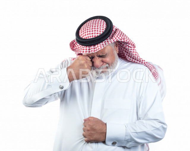 Portrait of an old Saudi Arab man who puts his hand over his eyes in a state of sadness and pain, close-up, a young Saudi man wearing a white dress with a shemagh and headband, white background, an elderly man feeling tired and very sad, the concept of fa