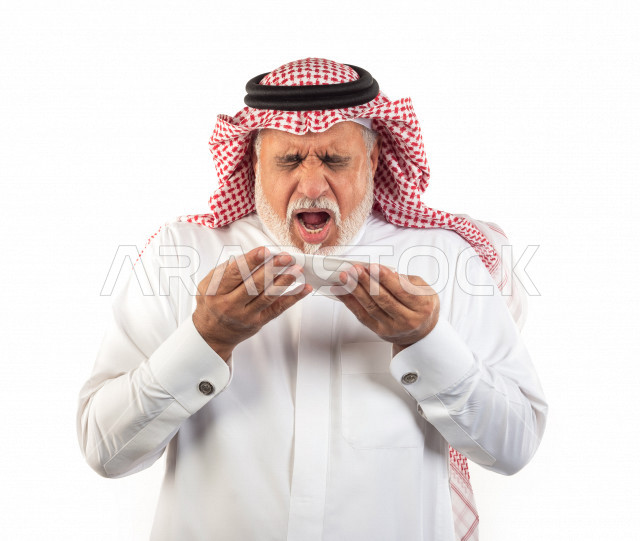 بورتريه رجل عربي سعودي كبير بالسن بيده منديل يضعه على أنفه والرغبة بالعطس , رجل شايب سعودي يرتدي ثوب أبيض مع شماغ وعقال , خلفية بيضاء , رجل مسن في حاله من العطس مفهوم لغة الجسد وتعابير الوجه