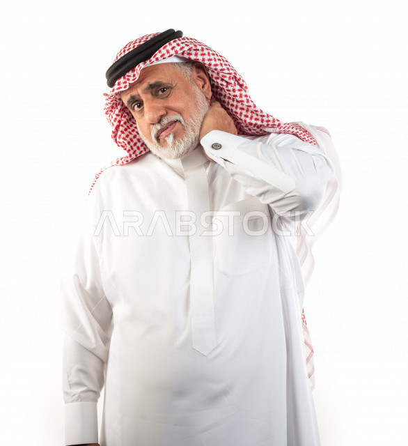 بورتريه رجل عربي سعودي كبير بالسن يضع يده على رقبته يشعر بحالة من الوجع والألم , صورة مقربة , شايب سعودي يرتدي ثوب أبيض مع شماغ وعقال , خلفية بيضاء , رجل مسن يشعر بالتعب والألم الشديد على رقبته , مفهوم تعابيرالوجه ولغة الجسد