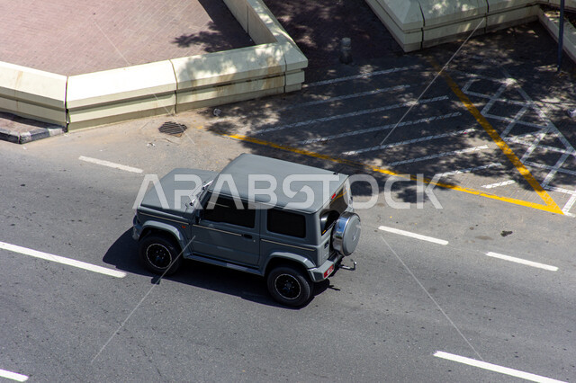 حركة مرور السيارات في الطرقات، فعاليات ومعارض متميزة، صورة من الاعلى لسيارة سوداء رباعية الدفع فارهة تسير في احدى شوارع مدينة دبي، معالم و أماكن سياحية مشهورة في الامارات العربية المتحدة