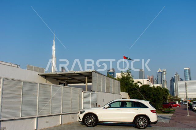 The growth and urban progress of Burj Khalifa, a close-up photo of a white four-wheel drive car parked on one of the streets of Dubai, famous landmarks and tourist places in the United Arab Emirates