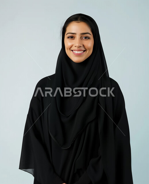 الوقوف باستقامة والنظر الى الكاميرا، صور شخصية للوثائق الرسمية، الملابس العصرية للمحجبات، الأناقة والإهتمام بالمظهر الخارجي، مفهوم النعومة والأنوثة، بورتريه مقرب لامرأة عربية خليجية سعودية محجبة ترتدي عباءة سوداء تنظر بايماءات السعادة والسرور، خلفية بيضاء
