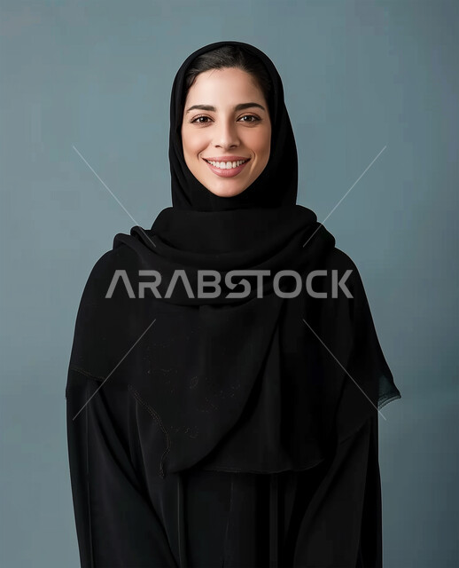 الأناقة والإهتمام بالمظهر الخارجي، مفهوم النعومة والأنوثة، ايماءات السعادة والسرور، الصور الشخصية للوثائق الرسمية، الأزياء العصرية للمحجبات، بورتريه مقرب لامرأة عربية خليجية سعودية محجبة ترتدي عباءة سوداء تنظر الى الكاميرا وتقف باستقامة، خلفية رمادية