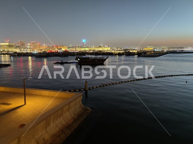 معالم الدوحة السياحية، كورنيش الدوحة على شاطئ الخليج العربي ليلا، القوارب الخشبية على الواجهة البحرية في دولة قطر، أماكن جذب واستقطاب السياح من انحاء العالم، خلفية الطبيعه