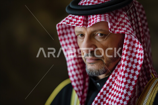 ارتداء الشماغ والبشت التقليدي، مفهوم الأناقة والاهتمام بالمظهر الخارجي، الاحترام والتقدير لكبار السن، بورتريه مقرب لرجل عربي سعودي خليجي من كبار الشخصيات يجلس في إحدى التجمعات بإيماءات الجدية والحزم، خلفية سوداء