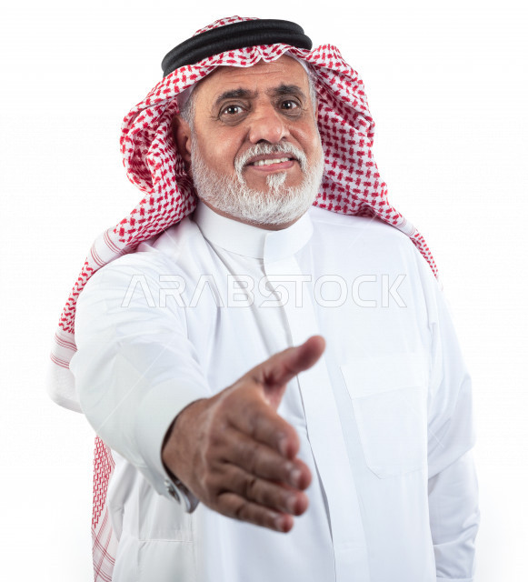 بورتريه رجل عربي سعودي كبير بالسن يمد يده للمصافحة , يرتدي ثوب أبيض مع شماغ وعقال , خلفية بيضاء , رجل مسن يمد يده للمصافحة وإلقاء التحية والسلام مفهوم تعابير الوجه ولغة الجسد المختلفة