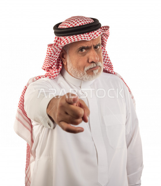 بورتريه رجل عربي سعودي كبير بالسن يشير بإصبعه بحالة من الغضب , يرتدي ثوب أبيض مع شماغ وعقال , خلفية بيضاء , رجل مسن غاضب يشير بإصبعه مفهوم تعبير الوجه