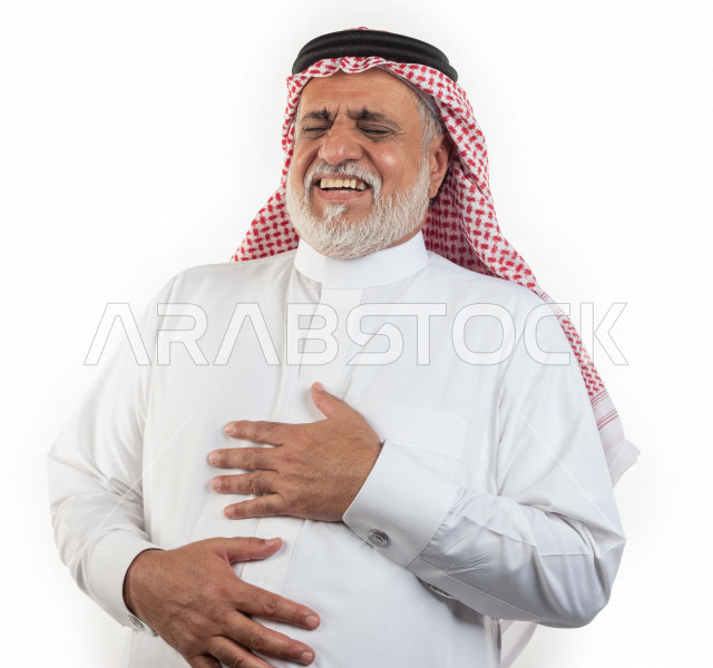 بورتريه رجل عربي سعودي كبير بالسن بإيدي متقاطعة وحالة من السعادة والفرح , يرتدي ثوب أبيض مع شماغ وعقال , خلفية بيضاء , رجل مسن يضحك ويبتسم مفهوم تعبيرالوجه 