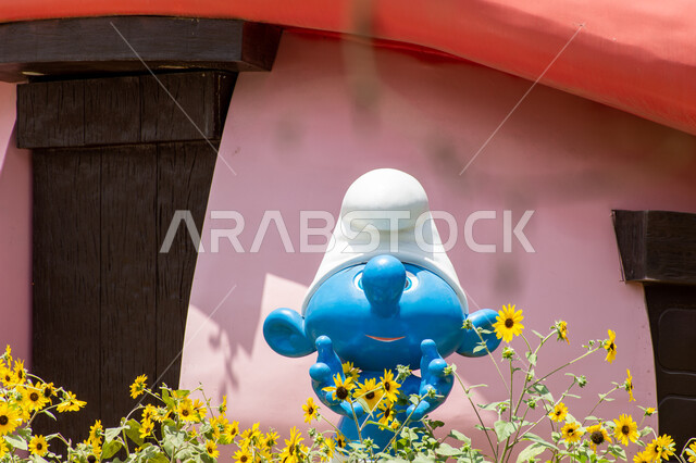 Ideal entertainment destinations for children, a 3D model of the Smurfs in blue inside the Miracle Garden, spending enjoyable times in public areas, famous tourist attractions, interest in planting flowers in the Smurfs Village in Dubai, gardens in the United Arab Emirates