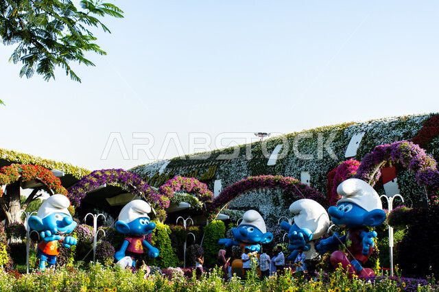 مجسمات ثلاثية الابعاد لمجموعه من السنافر بين الاشجار داخل حديقة ميركل غاردن, الاهتمام في زراعة الازهار في قرية السنافر في دبي، وجهات مثالية ترفيهية للأطفال, معالم سياحية مشهورة ,الحدائق في الإمارات العربية المتحدة ,قضاء اوقات ممتعة في المناطق العامة