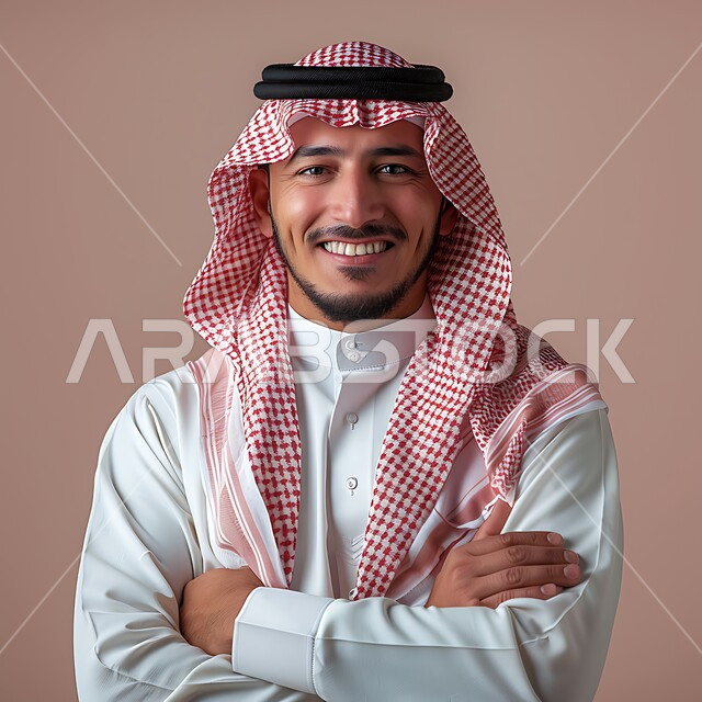 الوقوف بأيدي متقاطعة، التقاط صور شخصية للوثائق الرسمية، الأناقة والاهتمام بالمظهر الخارجي، مفهوم الوسامة والرجولة، بورتريه مقرب لرجل عربي خليجي سعودي مبتسم يرتدي الشماغ والثوب التقليدي ينظر الى الكاميرا بتعابير السرور والثقة بالنفس، خلفية وردية