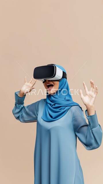 الأجهزة التكنولوجية والتقنيات الحديثة، الاندماج والتفاعل مع الواقع الافتراضي، الشعور بالمتعة والتسلية بمحاكاة العالم الخيالي, بورتريه لامرأة عربية خليجية سعودية محجبة ترتدي نظارات في آر ثلاثية الأبعاد، محاولة لمس العناصر الخيالية، خلفية بيج