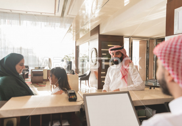 A Saudi family making reservations and entering at the hotel reception, tourism and hotel, happy family trip