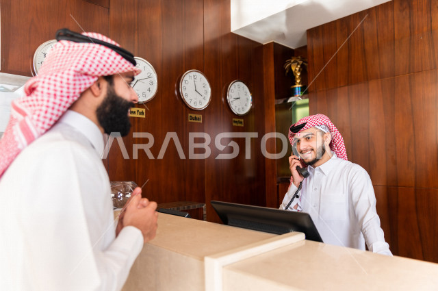 سائح خليجي سعودي يقوم بإجراءات الحجز والدخول لدى مكتب الاستقبال في الفندق , سياحة وفندقة