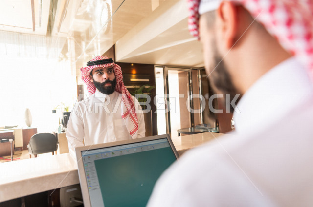 سائح خليجي سعودي يقوم بإجراءات الحجز والدخول لدى مكتب الاستقبال في الفندق , سياحة وفندقة