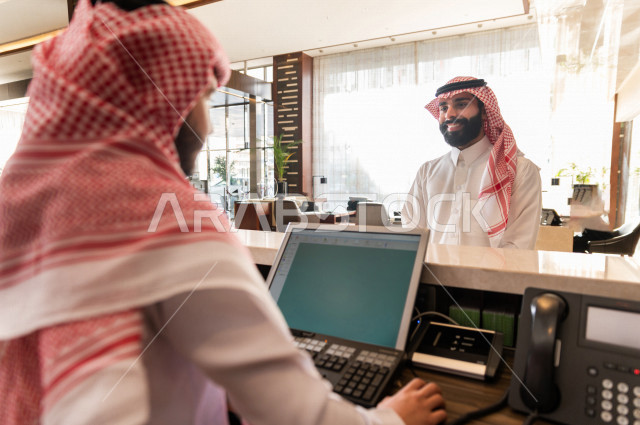 سائح خليجي سعودي يقوم بإجراءات الحجز والدخول لدى مكتب الاستقبال في الفندق , سياحة وفندقة