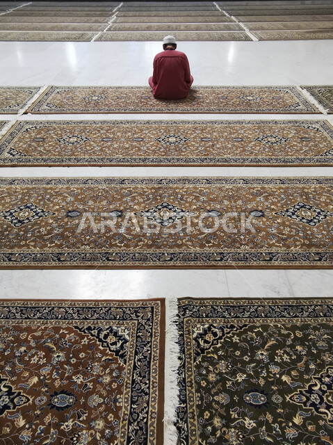 مفهوم العبادة والتقرب الى الله , توسعة الملك عبدالله للحرم المكي الشريف, الديكورات الداخلية و التصاميم المعمارية على الطراز الاسلامي الحديث, معالم دينية إسلامية مقدسة، رجل عربي خليجي سعودي يجلس في المسجد الحرام يقوم بتأدية فرض الصلاة في مكة المكرمة في السعودية