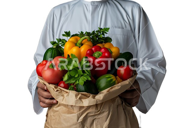 شراء الاحتياجات المنزلية، بورتريه مقرب لرجل خليجي عربي سعودي يرتدي الزي التقليدي يحمل بيده كيس الخضروات، السلع والمواد الغذائية المختلفة، الخضار الطازجة الشهية، مراكز التسوق في المملكة العربية السعودية، خلفية بيضاء