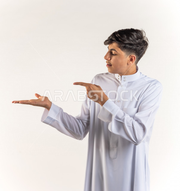 بورتريه شاب مراهق سعودي خليجي سعيد بإيماءات الوجه المختلفة ، تعابير وجه و يدين مختلفة ، خلفية بيضاء
