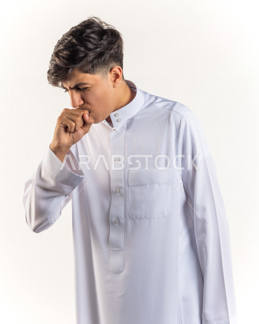 بورتريه شاب مراهق خليجي سعودي يضع يده أمام فمه وهو يسعل بإيماءات وجه ويدين مختلفة , خلفية بيضاء 