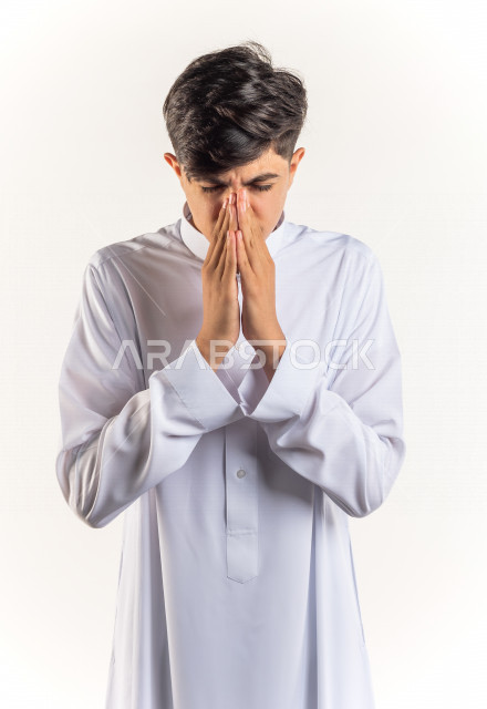 بورتريه شاب مراهق خليجي سعودي مريض يعطس داخل المناديل الورقيه بإيماءات وجه ويدين مختلفة ، يرتدي ثوب أبيض , خلفية بيضاء