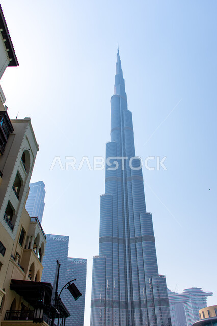 جذب واستقطاب السياح من جميع أنحاء العالم، المباني والمنشآت السكنية في مدينة دبي ، ناطحات السحاب والأبراج في الامارات العربية المتحدة، معلم سياحي مشهور، صورة من زاوية منخفضة لبرج خليفة الشهير وقت النهار
