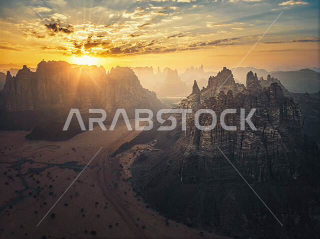 التكوينات الصخرية الطبيعية، الجبال والمرتفعات الصخرية في منطقة وادي ديسة في تبوك في المملكة العربية السعودية، الطبيعة الصحراوية في السعودية، السياحة في السعودية، منظر القمر في السماء في وقت الغروب