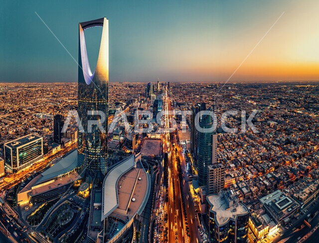 The urban growth and development of buildings and residential facilities, the advanced and modern design of towers and skyscrapers, attracting foreign tourists to famous landmarks and places, the architectural art of the Kingdom Tower in the city of Riyadh at sunset.